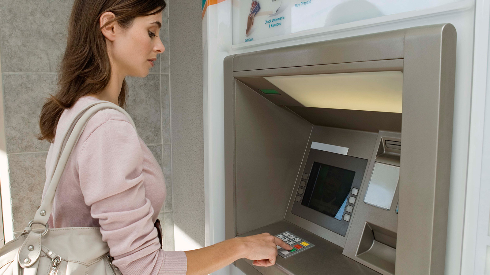 atm-woman-1600x900 Woman standing at ATM.