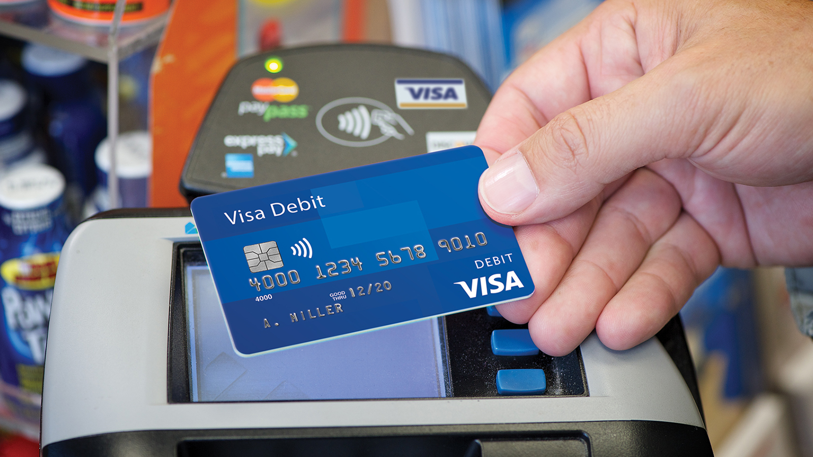 Presenting a contactless Visa debit card at checkout. Presenting a contactless Visa debit card at checkout.
