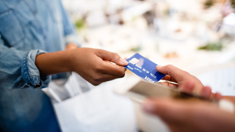 visa-analytics-platform-reducing-fraud-800x450 A Visa card being handed to a salesperson in a retail store