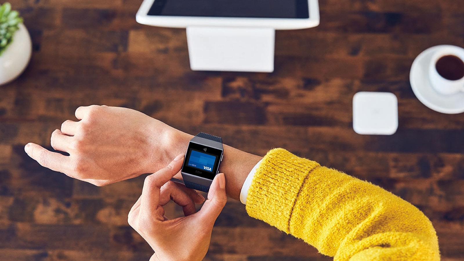 Woman using Visa Token on a Fitbit smartwatch.