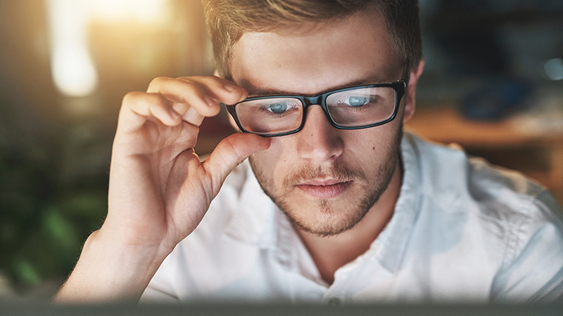 Man with spectacles using notebook