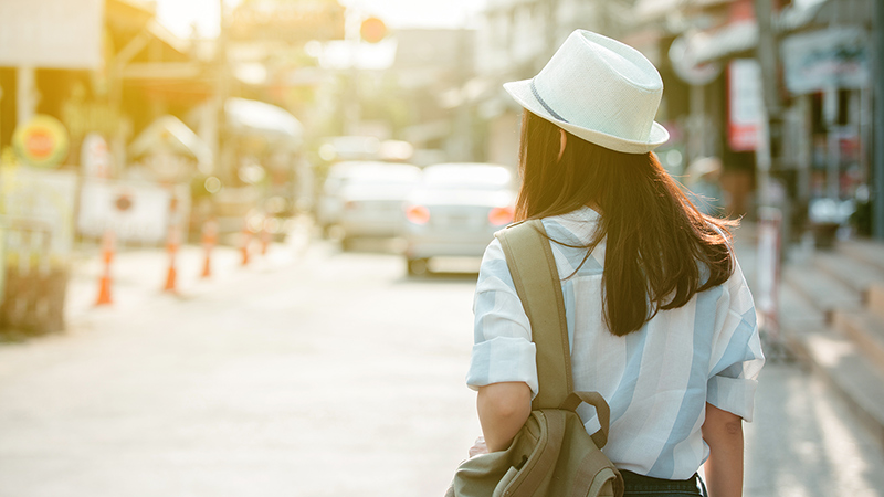 a walking woman in a hat